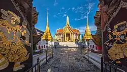 A Thai temple complex with several ornate buildings, and a lot of visitors